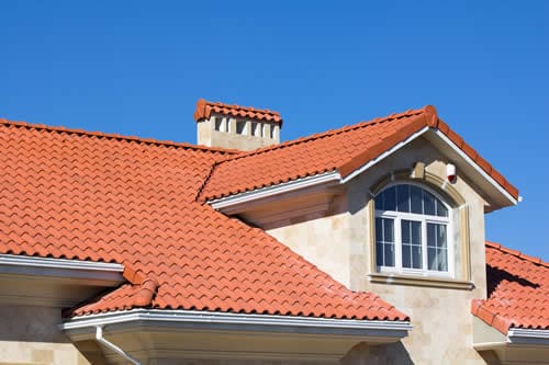 House with red tile roof and chimney.