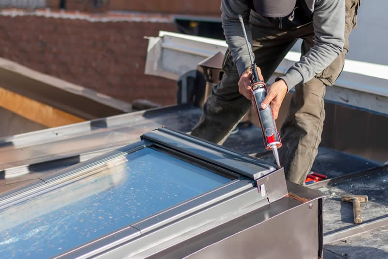 Roofer in Shelton WA fixing a skylight on the roof